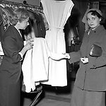 Två kvinnor tittar på kläder i butik. 1950-tal.