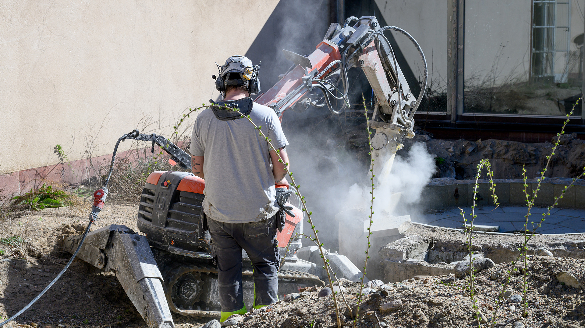 En maskin gräver upp fontänen på Örebro läns museum